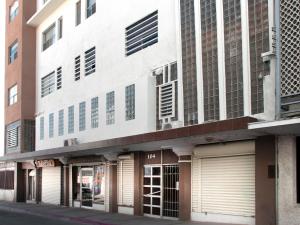 a large white building with two garage doors at Hotel Allende 104 in Chihuahua