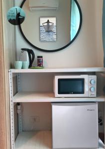 un microondas sentado en un estante junto a un espejo en Casa Lo Scoglio Della Ballerina en Livorno