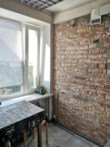 a brick wall in a room with a table at Апартаменты с панорамным видом на город in Zaporozhye