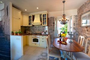a kitchen with a wooden table and a dining room at Luxury villa Kalalarga in the center of the town in Makarska