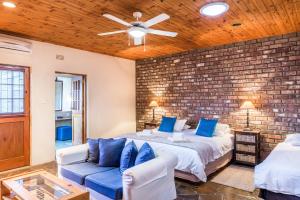 a bedroom with a bed and a brick wall at Karoo Lodge in Prince Albert