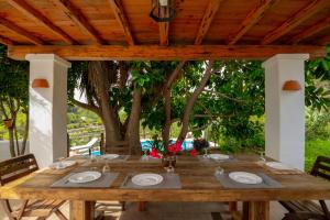 una mesa de madera con platos bajo un árbol en Villa Historica, en San Miguel de Balansat