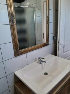 ein Badezimmer mit einem weißen Waschbecken und einem Spiegel in der Unterkunft Apartment Luka in Bibinje