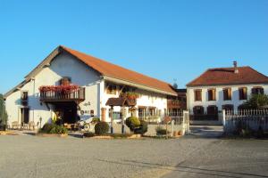 a large white building with flowers on a balcony at Logis Hôtel Les 3B in Nouilhan