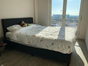 a bed with a comforter and stuffed animals on it at Appartement verhuur Zeedijk Middelkerke Sunbeach in Middelkerke