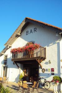 a bar with a balcony on the side of a building at Logis Hôtel Les 3B in Nouilhan
