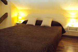 a bedroom with a large bed with two pillows at Logis Hôtel Les 3B in Nouilhan