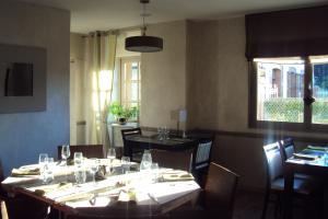 a dining room with a table and chairs and a window at Logis Hôtel Les 3B in Nouilhan