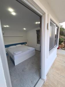 a bedroom with a bed and a large window at Martini Vacation Home in Sarandë