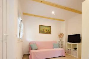 salon z różową kanapą i telewizorem w obiekcie Apartment in Silo - Insel Krk 39710 w mieście Šilo