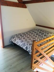 1 dormitorio con cama y escalera de madera en Gîte de la Salamandre - 4 à 8 personnes, en Lapoutroie