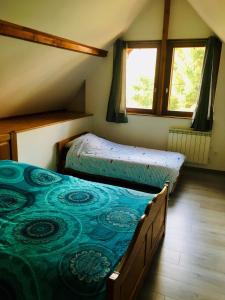 2 camas en una habitación con 2 ventanas en Gîte de la Salamandre - 4 à 8 personnes, en Lapoutroie