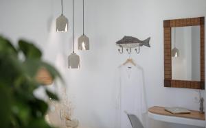 a bathroom with a mirror and a dress hanging from a wall at HORA SUITES in Naxos Chora