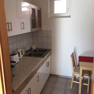 a small kitchen with white cabinets and a sink at Apartment in Balatonbereny 40988 in Balatonberény