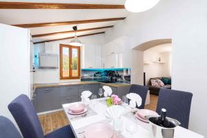 a kitchen and dining room with a table and chairs at Holiday home in Veli Losinj 40979 in Veli Lošinj
