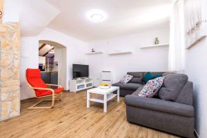 una sala de estar con un sofá y una silla en Holiday home in Veli Losinj 40979, en Veli Lošinj
