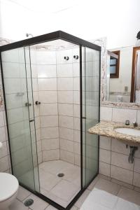 um chuveiro com uma porta de vidro na casa de banho em Pousada Vista da Pedra Atibaia em Atibaia