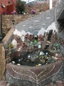einen Miniaturgarten mit einem Brunnen in einem Felsen in der Unterkunft Guest House Kaskad in Kislowodsk