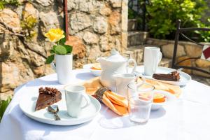 a white table with plates of food on it at B&B Villa Dubrovnik Garden in Dubrovnik