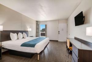 a hotel room with a large bed and a desk at Motel 6-Tucson, AZ-Downtown in Tucson +18 photos