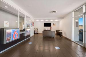 a lobby with a waiting room with a desk and a television at Motel 6-Tucson, AZ-Downtown in Tucson