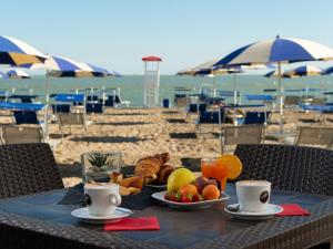 a table with a plate of food on the beach at Villa in Albarella near Venice Beach in Isola Albarella