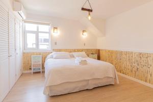 Un dormitorio con una cama grande y una ventana en Dolce Vita - Alojamiento Histórico, en Puerto Varas
