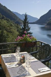 a table with wine glasses and a view of a lake at Hotel Al Lago in Vogorno