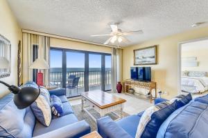 a living room with a blue couch and a view of the ocean at Commodore Resort #703 by Book That Condo in Panama City Beach