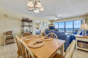 a dining room with a table and a blue couch at Commodore Resort #704 by Book That Condo in Panama City Beach