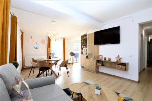 a living room with a couch and a tv on a wall at Apartament Central "Casa D'Alba" in Alba Iulia