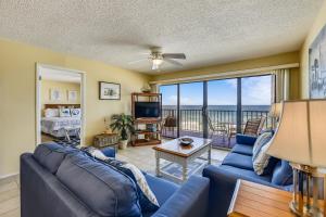 a living room with a blue couch and a view of the ocean at Commodore Resort #704 by Book That Condo in Panama City Beach