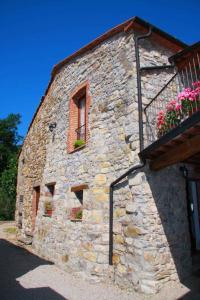 a stone building with a window and flowers on it at Apartment in Montieri/Toskana 38264 in Montieri