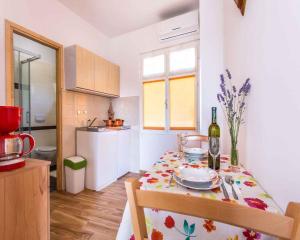 瓦比尼科的住宿－Apartment in Vrbnik/Insel Krk 36873，小厨房配有带1瓶葡萄酒的桌子