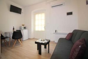 Apartment in Porec/Istrien 36967 في بوريتش: غرفة معيشة مع أريكة وطاولة