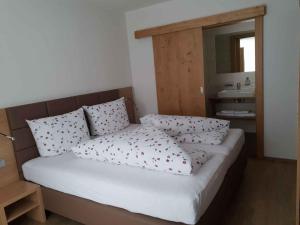 una camera da letto con letto, cuscini e lavandino di Apartments in Kappl/Paznauntal 36440 a Kappl