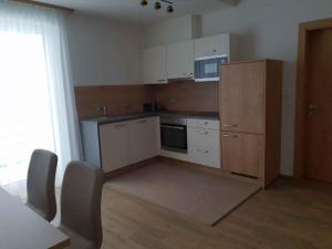 a small kitchen with white cabinets and a microwave at Apartments in Kappl/Paznauntal 36440 in Kappl