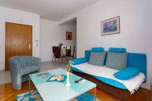 ein Wohnzimmer mit einer blauen Couch und einem Tisch in der Unterkunft Apartments in Vrbnik - Insel Krk 36771 in Vrbnik + 9 Fotos