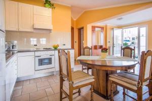 a kitchen with a table and chairs and a kitchen with yellow walls at Apartment in Vrbnik/Insel Krk 36770 in Vrbnik