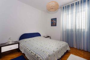 ein Schlafzimmer mit einem Bett und einem großen Fenster in der Unterkunft Apartments in Vrbnik - Insel Krk 36771 in Vrbnik