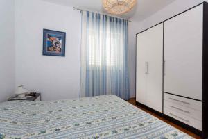 ein Schlafzimmer mit einem Bett, einer Kommode und einem Fenster in der Unterkunft Apartments in Vrbnik - Insel Krk 36771 in Vrbnik