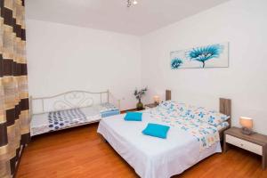 a bedroom with a bed with blue pillows on it at Apartment in Vrbnik/Insel Krk 36842 in Vrbnik