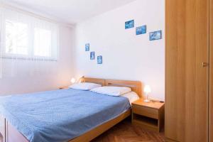 a bedroom with a blue bed and a window at Studio in Vrbnik/Insel Krk 36776 in Vrbnik