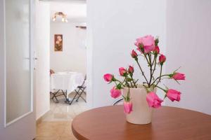 un vaso con fiori rosa seduto su un tavolo di Studio in Vrbnik/Insel Krk 36776 a Vrbnik