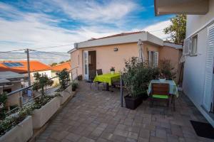 a patio with a green table and chairs and a building at Apartment in Vrbnik/Insel Krk 36770 in Vrbnik