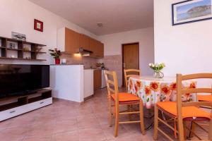a kitchen and a dining room with a table and chairs at Apartment in Vrbnik/Insel Krk 36856 in Vrbnik