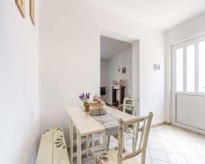 a white dining room with a table and chairs at Apartment in Vrbnik/Insel Krk 36858 in Vrbnik