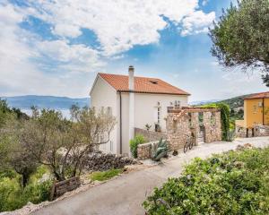 a large white house with a stone wall at Apartment in Vrbnik/Insel Krk 36858 in Vrbnik