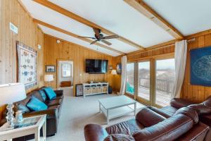 a living room with leather couches and a tv at Hunter Haven #6HHH in Hatteras