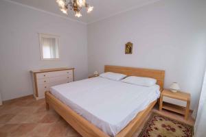 sypialnia z dużym białym łóżkiem i komodą w obiekcie Studio in Mali Losinj 36544 w miejscowości Mali Lošinj